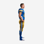 Custom mens american football uniform side view showing white triangular jersey side panel, short set-in sleeves with gold and white stripe cuff, and full gold pants with white outer leg stripe