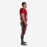 Side view of mens red and gray custom football uniform showing gray shoulder panel on jersey and bold red outer-leg stripe on gray football pants