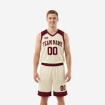 Men's basketball uniform sets in cream and maroon showing V-neck jersey with arced team name and matching shorts with maroon waistband - front view