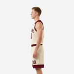 Opposite side view of men's custom basketball uniform set in cream with maroon shoulder panels and coordinating basketball shorts
