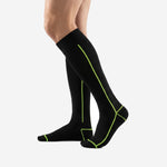 Custom black and green soccer socks lateral view showing full over-the-calf length and neon green foot panel accent