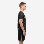 Side view of men's black and gold soccer uniform showing Athletic Gold sleeve cuff trim and matching shorts side stripe