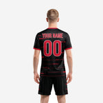 Close detail of black soccer jersey with crimson red speed stripe sublimation print and red sleeve cuff trim