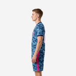 Steel blue camo custom soccer uniform kit side profile view showing hot pink side stripe and navy blue V-neck trim on mens jersey