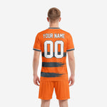 Close-up of brushstroke stripe detail on custom orange soccer jersey with Graphite bands and white team name print