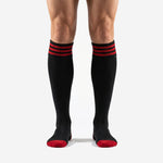 Mens custom red and black soccer socks with triple red stripe cuff band shown from the front on male model