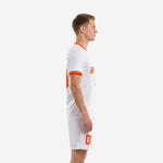 Orange and white men soccer kit close-up showing moisture-wicking polyester fabric and matching shorts with orange leg number