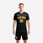 Mens custom all black soccer uniform with Athletic Gold pinstripe and arched team name on jet black jersey and matching shorts - front view