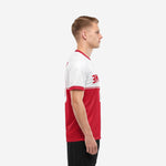 Custom red and white soccer jersey side view showing colorblock panel construction and red sleeve cuff trim on male model