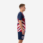 Custom men's soccer team uniform side view showing crimson and white splash strokes on navy jersey and matching shorts