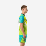 Custom soccer uniform men side view showing teal to neon yellow diagonal gradient splash print on jersey and matching teal shorts