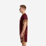 Full maroon soccer uniform with gold geometric side panel trim and matching shorts, right side view