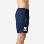 Side view of navy and gold custom team basketball shorts showing torch graphic on right leg panel, side split at hem, and elastic drawcord waistband