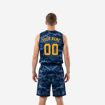 Opposite side view of navy and gold basketball uniform set showing digital camo pattern across jersey body and shorts panel