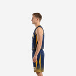 Side view of navy and gold sublimated basketball uniform showing gold side panels on jersey and shorts with dot-fade gradient hem