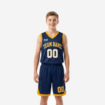 Navy and gold youth basketball uniforms two-piece set showing navy jersey with gold V-neck and armhole binding and matching navy shorts with gold hem trim worn by youth boy model, front view