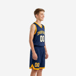 Custom navy and gold youth basketball uniform jersey showing arched gold team name across chest and white-outlined front number 00 with matching navy shorts on youth boy model, front angle