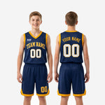 Three-quarter side view of custom printed youth basketball uniforms in navy and gold showing V-neck binding detail, shorts elastic waistband, and gold hem band on youth boy model