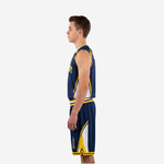 Side view of navy and gold youth basketball uniform showing white side insert on jersey body and sweeping gold and white diagonal panel on shorts leg