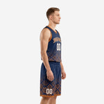 Adult male model wearing custom navy basketball uniform with orange Aztec pattern on the lower jersey and matching shorts