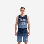 Navy blue basketball uniform full set with white pinstripe gradient fade, arched team name, and front number on a male model - front view
