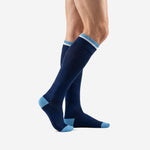 Side view of custom navy blue soccer socks showing sky blue contrast toe block and ribbed calf panel on adult male model