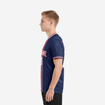Right side view of custom sublimation soccer jersey design in Navy Blue with Crimson center stripe and white contrast trim on male model