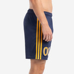 Custom navy and gold soccer shorts showing double Athletic Gold side stripes running from waistband to hem, left side view on adult male model