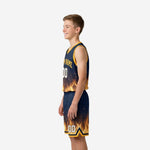 Side view of navy and gold youth basketball uniform set showing armhole binding and flame print at jersey hem
