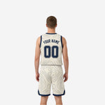 Cream-white side view of reversible basketball uniform showing navy topographic line pattern across jersey and shorts