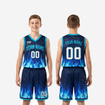 Back view of navy youth basketball uniforms with player name and back number above blue flame graphic rising from hem