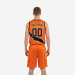Opposite side view of custom reversible basketball uniform showing orange body with black trim and contrasting slash graphic on the shorts leg.