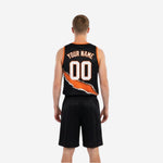 Side view of orange and black reversible basketball uniform showing V-neck binding and sleeveless armhole cut on black jersey side.