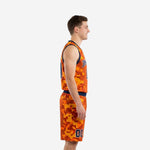 Side view of orange and blue basketball uniforms showing the digital camo pattern wrapping the jersey and matching shorts with navy waistband