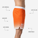 Close-up of the hem area on orange basketball shorts showing the halftone dot fade, white number zone, and side split construction