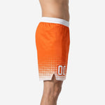 Side view of orange custom basketball shorts showing white elastic waistband, halftone dot fade, and side split at hem