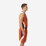Custom orange basketball uniform front view with arched team name in navy, player number, and curved white side panels on the jersey