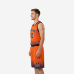 Side view of orange and navy custom basketball uniform showing halftone dot fade on jersey hem and shorts