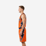 Side view of orange basketball uniform showing full navy and white lightning bolt panel running the length of the jersey and matching shorts