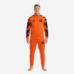 Men's orange and black custom soccer tracksuit front view showing full-zip jacket and tapered pants with splash-brush sleeve panels