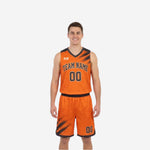 Front view of custom orange and black reversible basketball uniform with diagonal brush-stroke panels and arched team name