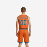 Orange reversible basketball uniform side view showing steel blue trim, topographic pattern, and matching shorts with blue hem binding