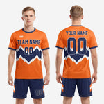 Full body overview of men's custom orange and navy soccer uniform kit with complete sublimated geometric design