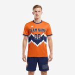 Front view of custom orange soccer uniform set with navy geometric mountain graphic and matching navy shorts for men