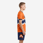 Left side view of orange and navy custom soccer uniform showing short sleeve jersey and sublimated navy shorts