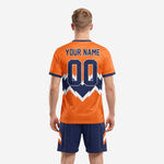 Back detail of custom orange soccer jersey with navy crew neck collar, team name, and player number sublimation