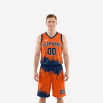 Custom orange basketball uniform with navy ink-splash sublimation pattern, team name and number on jersey and matching shorts, front and back view