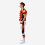 Left side view of custom kids football uniforms in orange and navy with white football pants and navy orange leg stripe