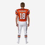 Right side view of youth tackle football uniforms showing orange jersey sleeve number and matching white pant side stripe detail