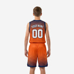 Opposite side view of orange youth basketball uniform set showing navy armhole binding, side panel, and shorts hem detail on youth player